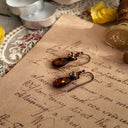 An angled view of the amber and topaz earrings, highlighting the "perfectly weathered" look of the antiqued bronze and the soft, misty quality of the teardrop stone.