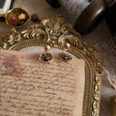 A close-up of the reverse side, showing the signature scrollwork texture that identifies it as 1928 Jewelry, as well as significant, honest wear on the clips.