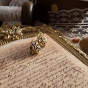 An angled view of the Rococo filigree earrings, highlighting the dimensional craftsmanship and the brilliant fire of the clear crystal rhinestones.