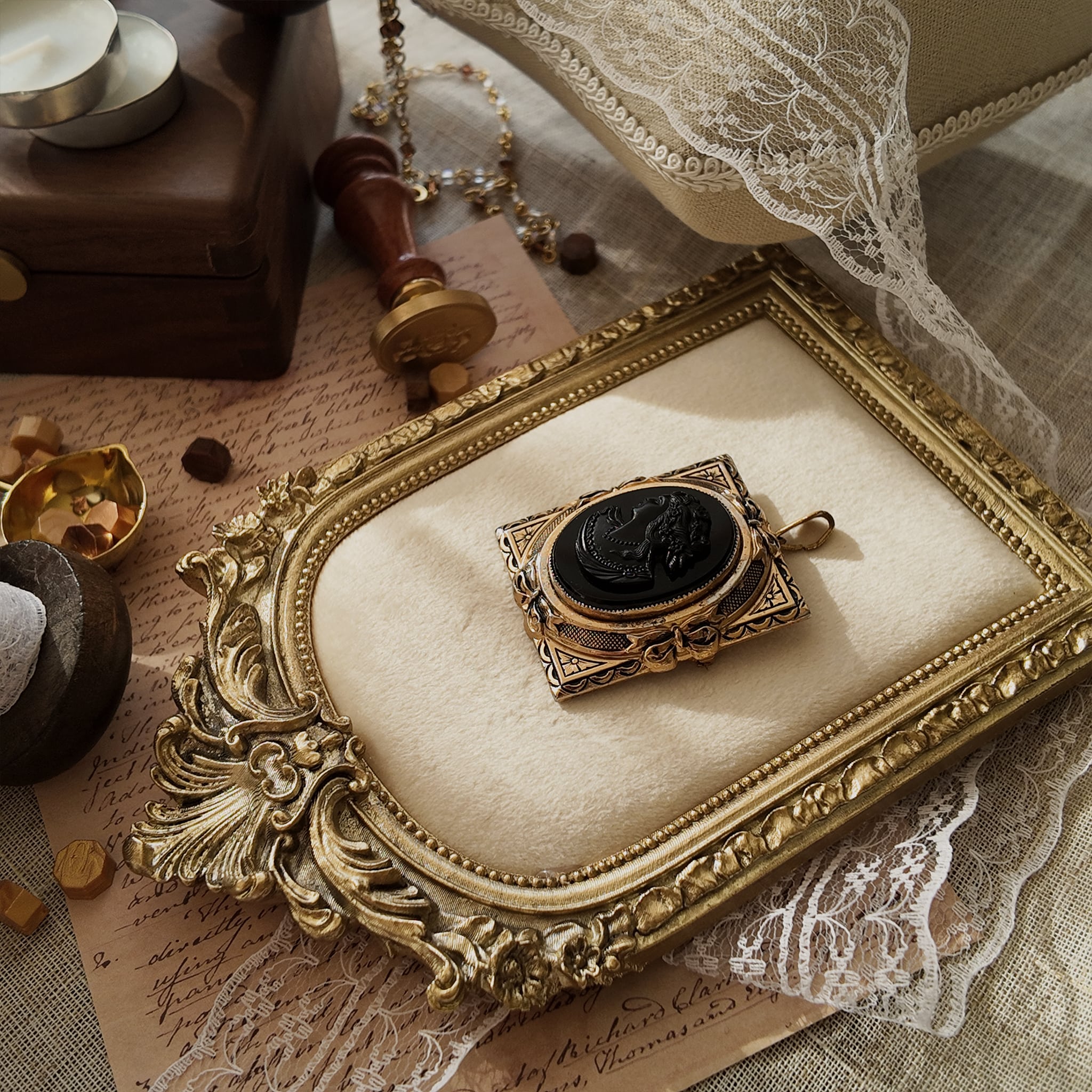 The "Hearthside," a 1940s antique Coro cameo brooch, featuring a carved black glass lady in profile set in a heavily worn, ornate gold-tone frame.