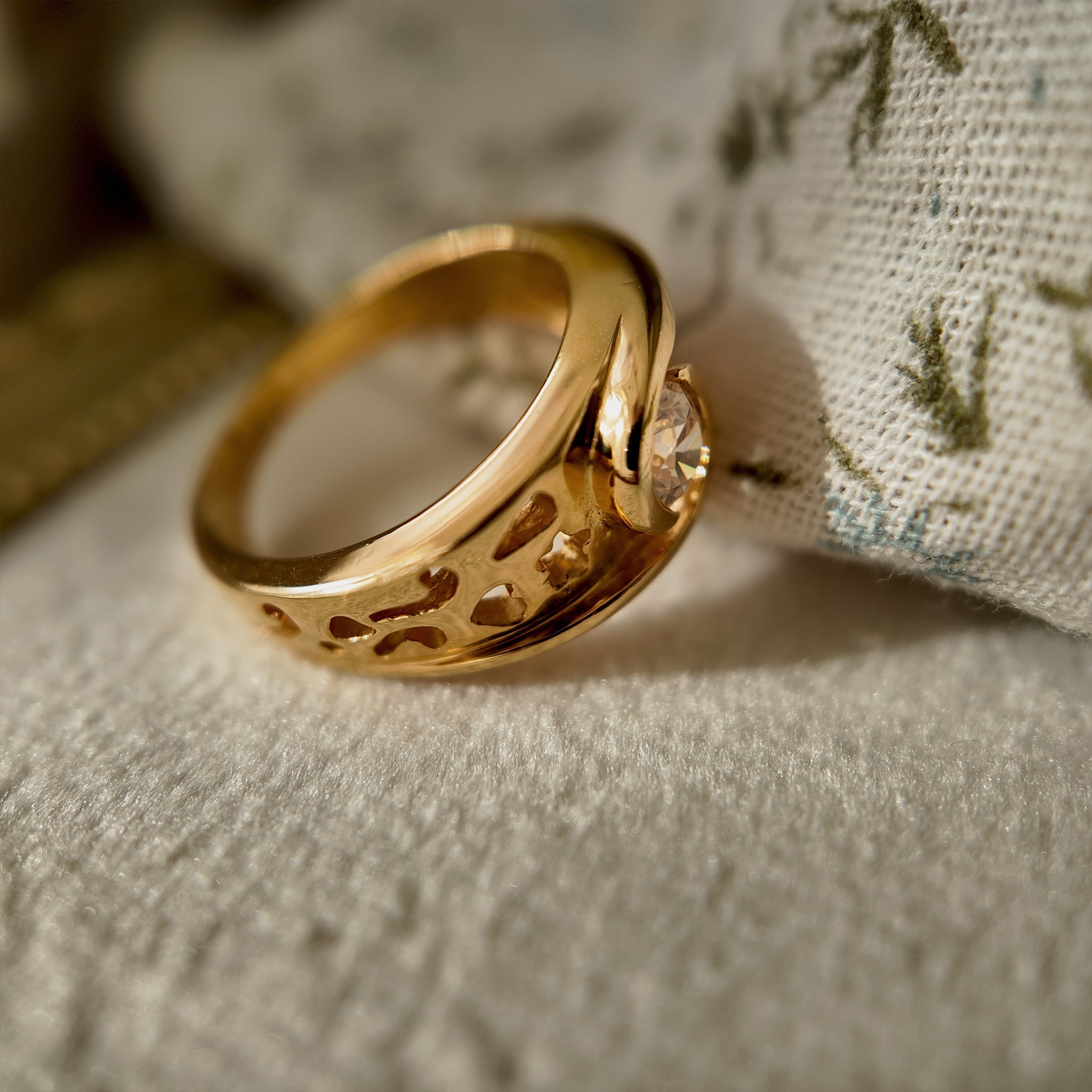 The 23k gold-plated ring features a round glass diamond, and the band is openwork-engraved with intricate patterns. The vintage ring is displayed upright in a velvet case, allowing for a clearer view of its shape and the condition of the plating.