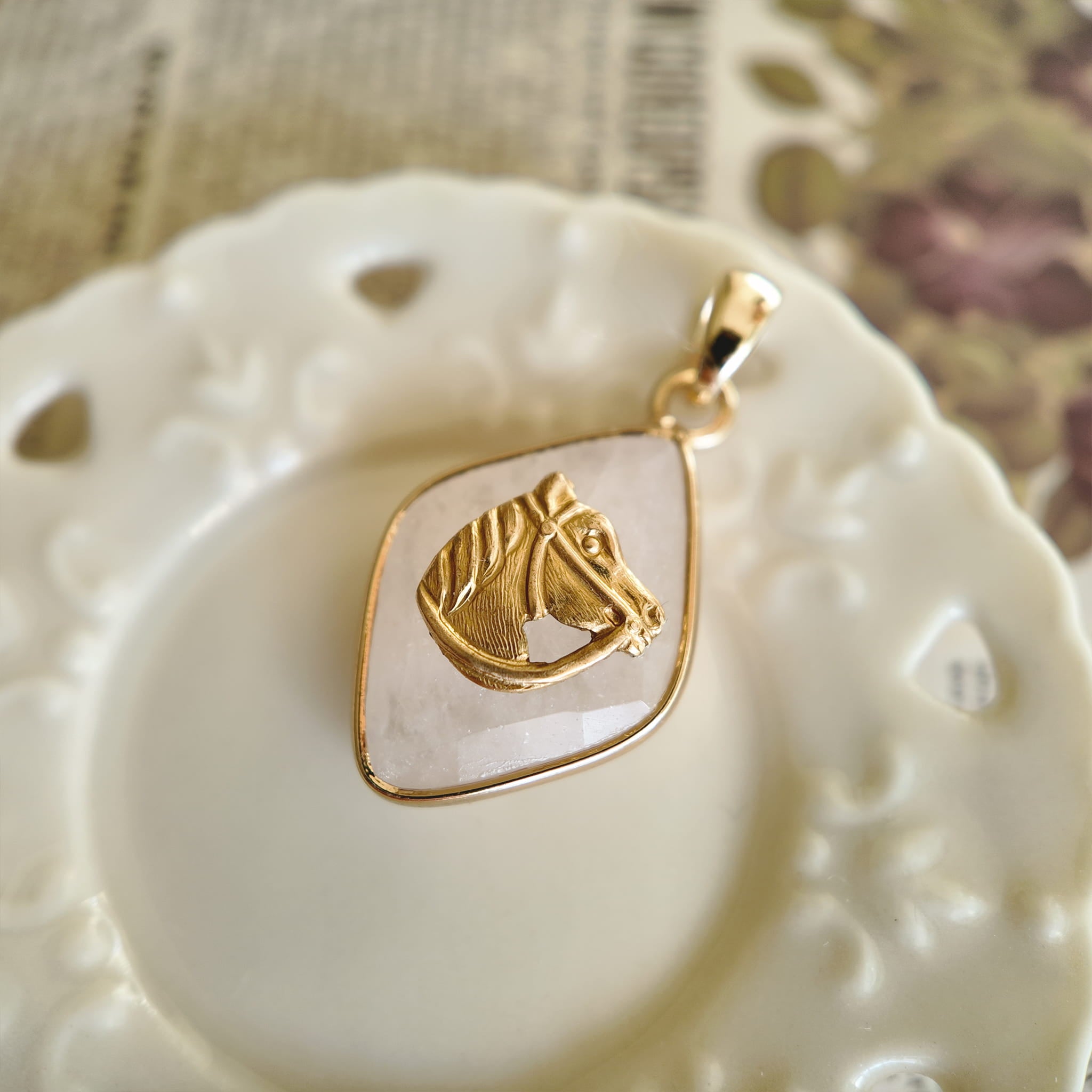 Close-up detail of the noble and intricately detailed vintage brass horse head against the clear stone.