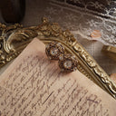 A macro shot detailing the intricate, web-like filigree work and the sparkling, hand-set quality of the crystal rhinestones on these vintage earrings.