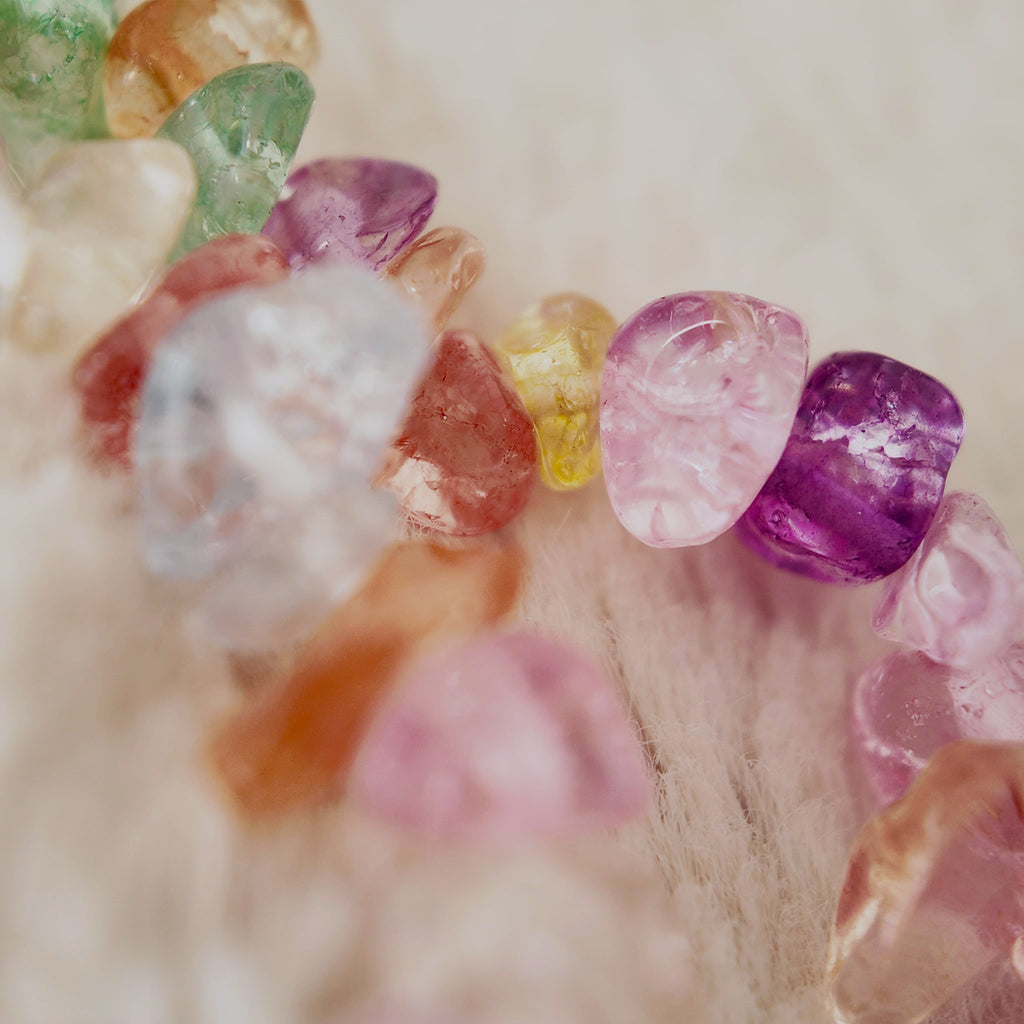 A macro shot detailing the irregular, polished shapes of the natural stone chips in candy-like colors of pink, purple, green, and yellow.