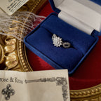 A close-up display of the ring inside its original box shows the glass and diamonds sparkling; the ring appears brand new, just like in its original box.