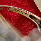 The high-powered lens reveals the steel stamp on the inner band of the ring, which reads "Thailand," indicating that the ring was made in Thailand.
