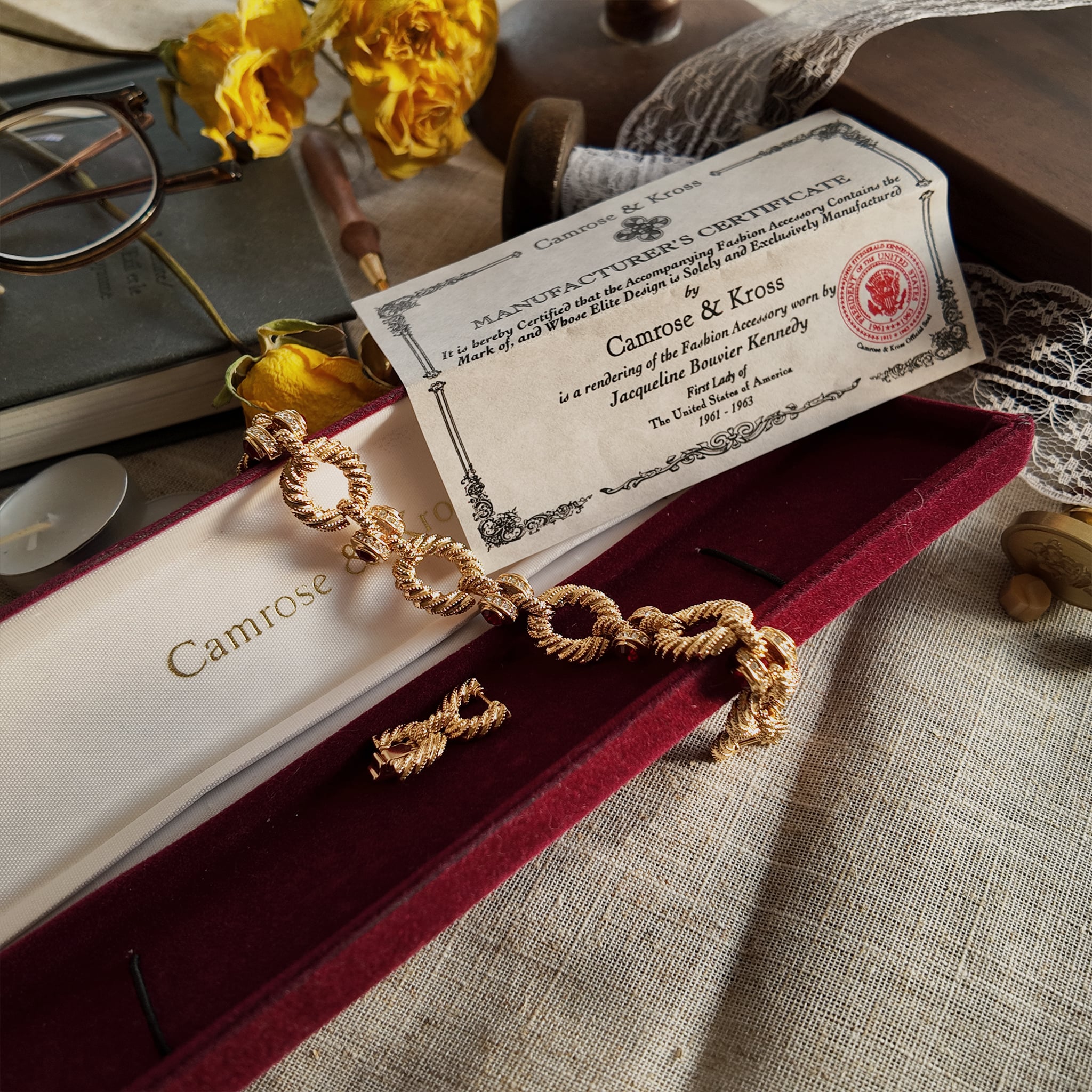 The gold-brushed bracelet, inlaid with red gemstones, sits on its original, open red velvet packaging box, alongside a complete official certificate of authenticity, showcasing its overall appearance.