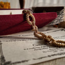 The gold bracelet was displayed suspended in the air, along with the bottom of the original red velvet box, appearing as if it were brand new.