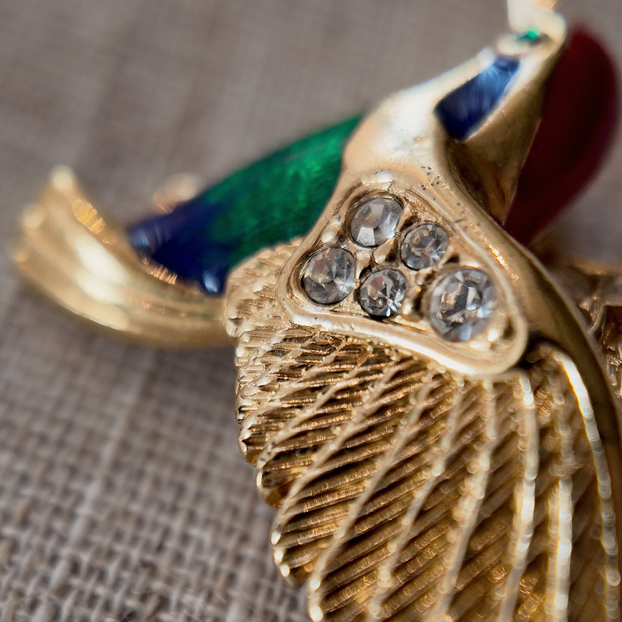 Showcases the rhinestones set on the hummingbird brooch, as well as details of its wings.