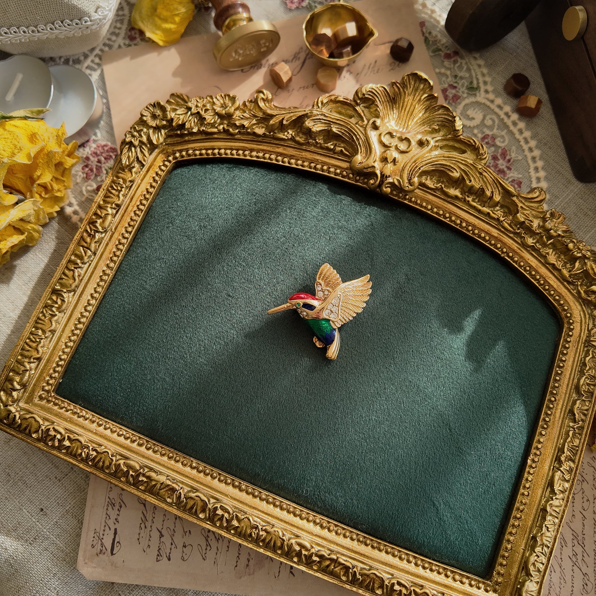 A colorful hummingbird brooch, cute, gold, and lifelike.