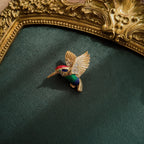 A gold brooch in animal form. Rich gold color, elegant bird in flight. Small design, polychrome enamel.