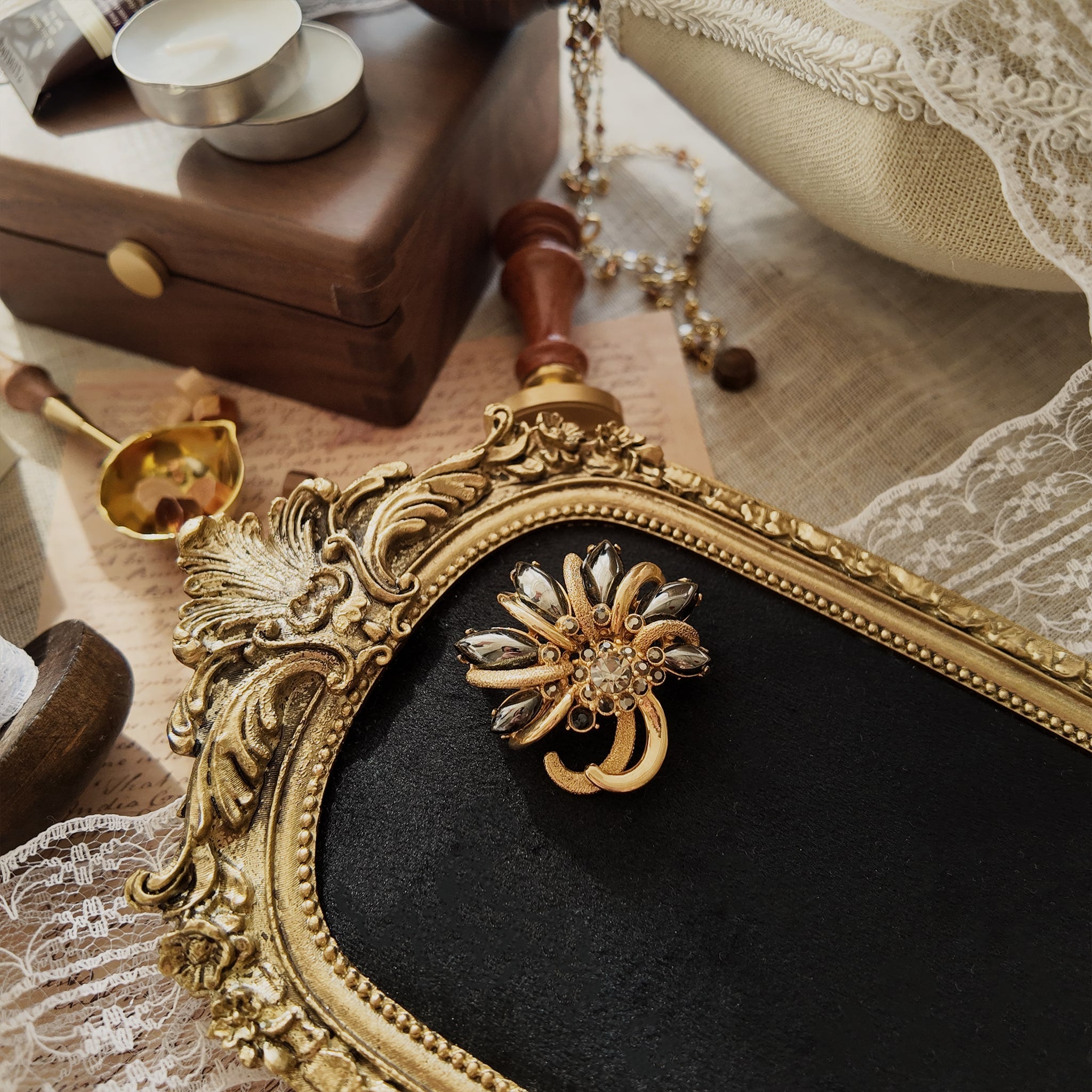 This vintage maple leaf-shaped jewelry brooch is from the brand "HOLLICRAFT." It features a gold-plated maple leaf design inlaid with obsidian and grey-black rhinestones. Like a castle in the desert, it's a classic piece combining gold and black.