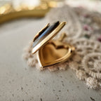 The heart-shaped photo box is half-open, with a gold-plated design.