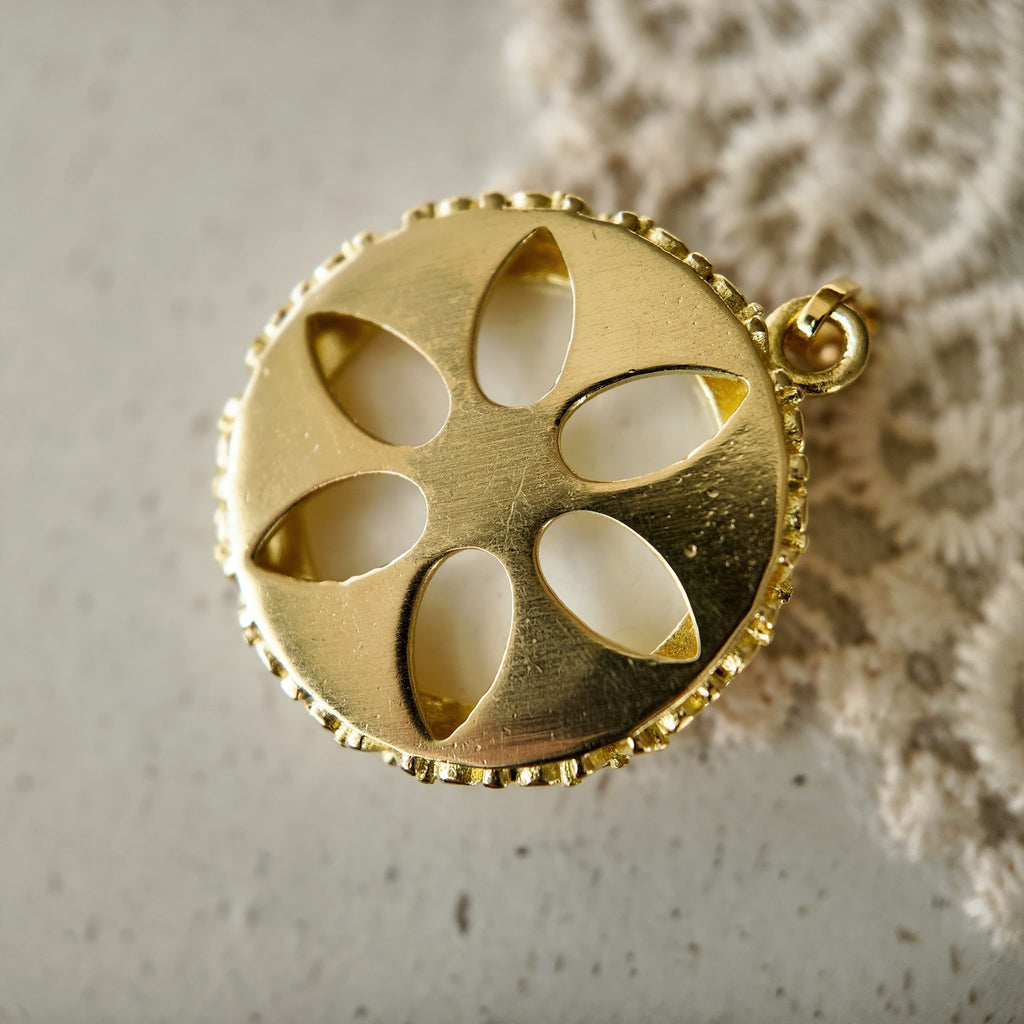 Vintage gold warrior pendant with an open back and retro shoulder strap, a symbol of courage.