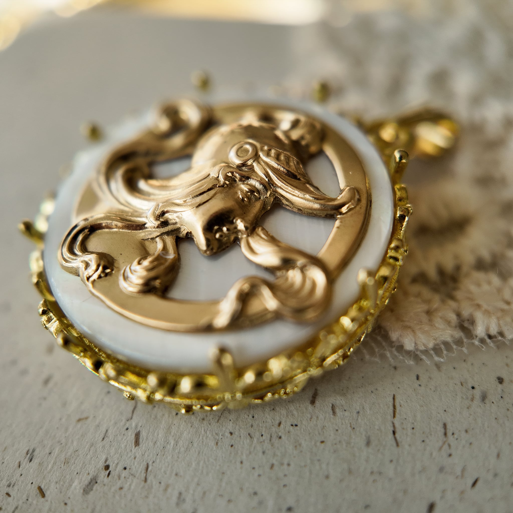 A vintage gold warrior pendant, inlaid with white mother-of-pearl, featuring reconstructed vintage accessories.