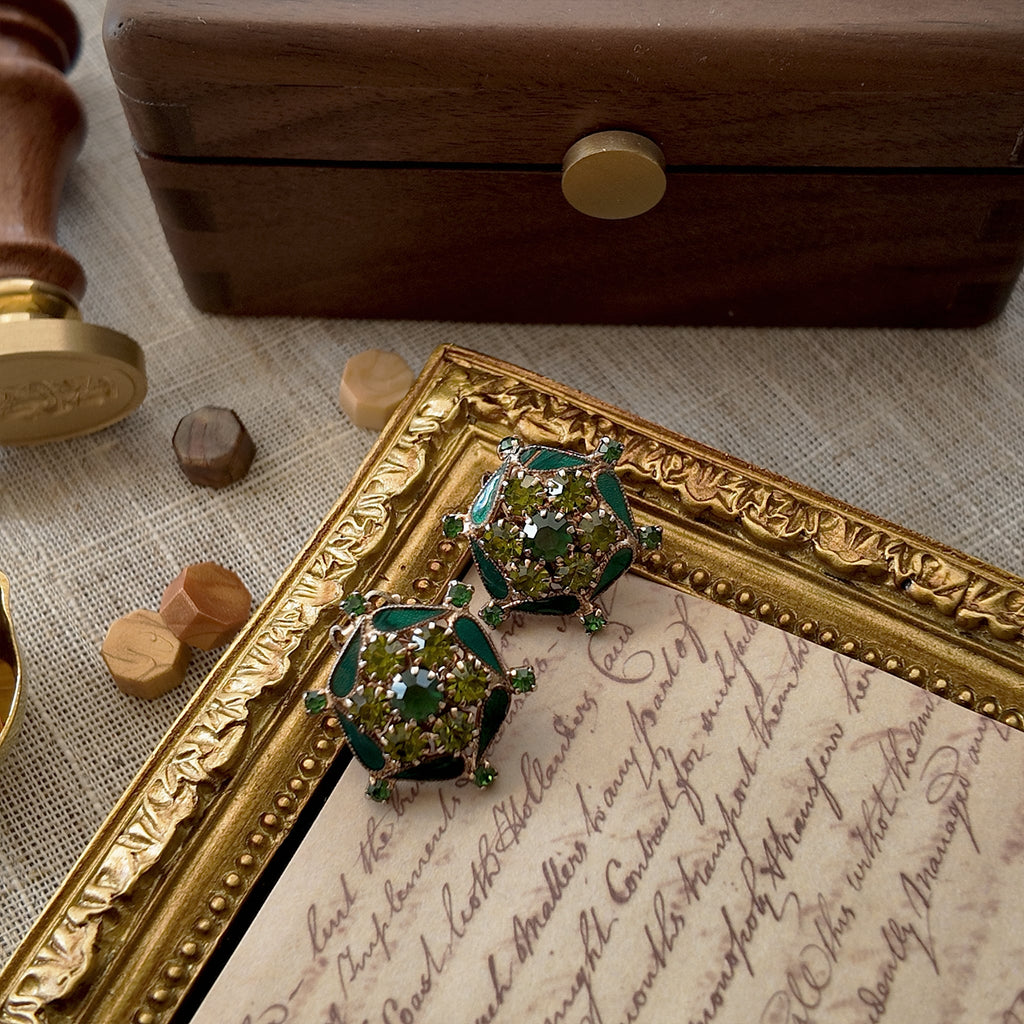 A vintage green brooch, combining colored enamel and high-quality rhinestones. A classic emerald green piece that exudes elegance.