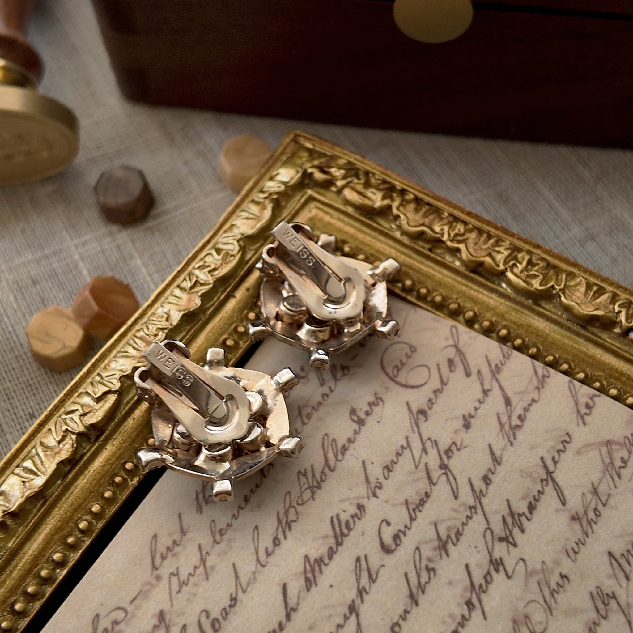 The back of the vintage clip-on earrings is engraved with the WEISS logo, signifying that these vintage clip-on earrings are genuine vintage items and come from the brand WEISS.