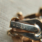 A close-up of the logo stamp on the back of the vintage brand item reveals the brand name "WEISS" more clearly.