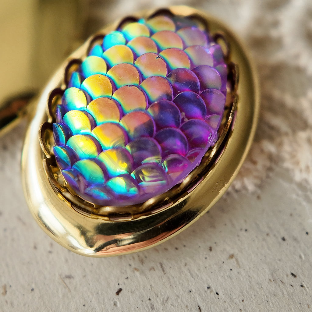 A pendant with laser-engraved fish scale design, reminiscent of the vintage era, in excellent condition. It features a dreamy, iridescent purple hue. A truly enchanting vintage pendant.
