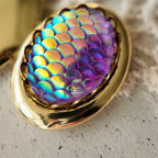 A pendant with laser-engraved fish scale design, reminiscent of the vintage era, in excellent condition. It features a dreamy, iridescent purple hue. A truly enchanting vintage pendant.