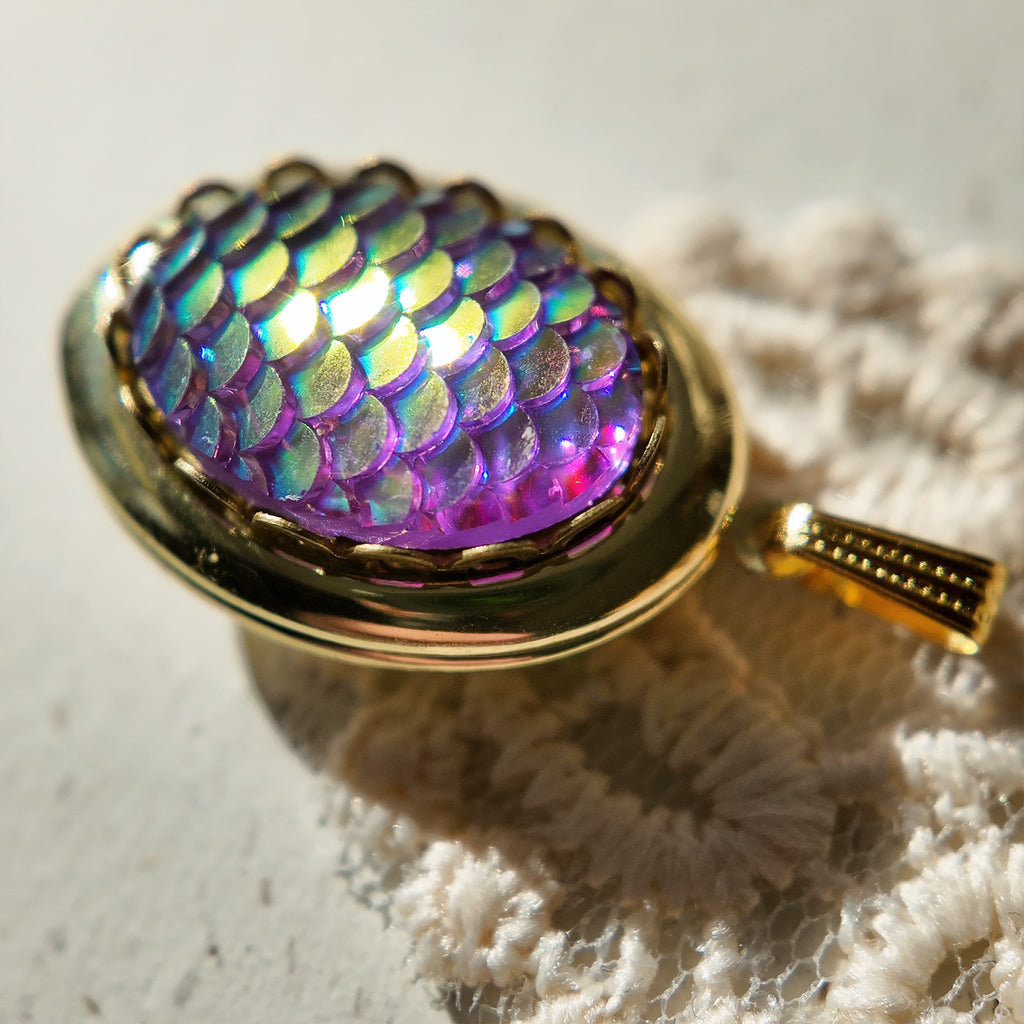 The fish-scale design of the pendant shimmers in the sunlight, resembling jewelry made of mermaid skin. A legend of the sea, a treasure of the deep.