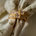 A gold ring with A gold ring set with two rows of glass diamonds set through a floral fabric