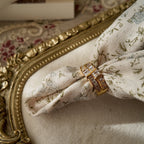 A gold ring with A gold ring set with two rows of glass diamonds set through a floral fabric side view