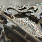 This image showcases the back of the opal brooch under high magnification, revealing subtle hammered textures and the finishing on the metal parts.