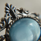 This opal brooch is shown under a high-powered microscope, revealing the stone's texture, surface curvature, and any imperfections.