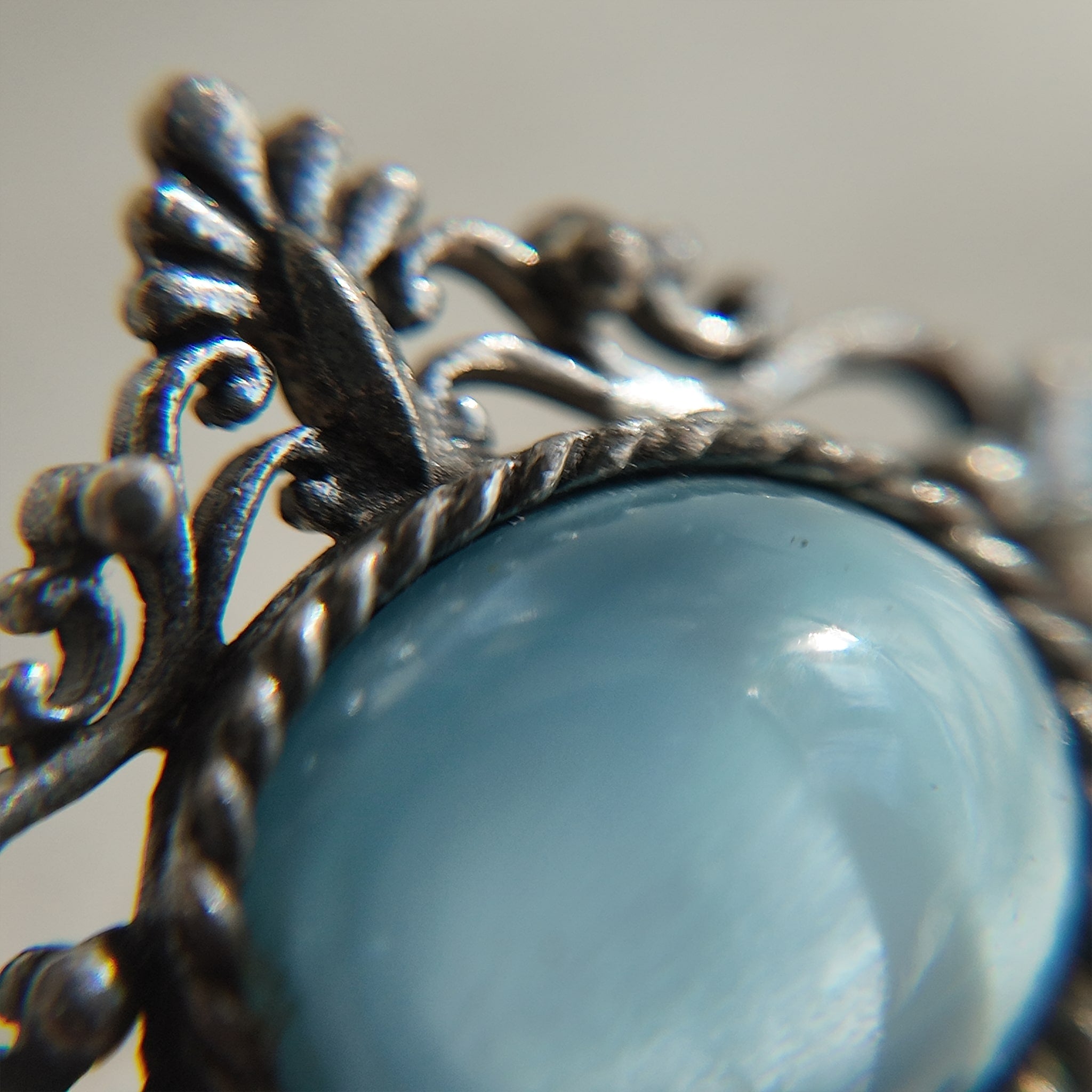 This opal brooch is shown under a high-powered microscope, revealing the stone's texture, surface curvature, and any imperfections.