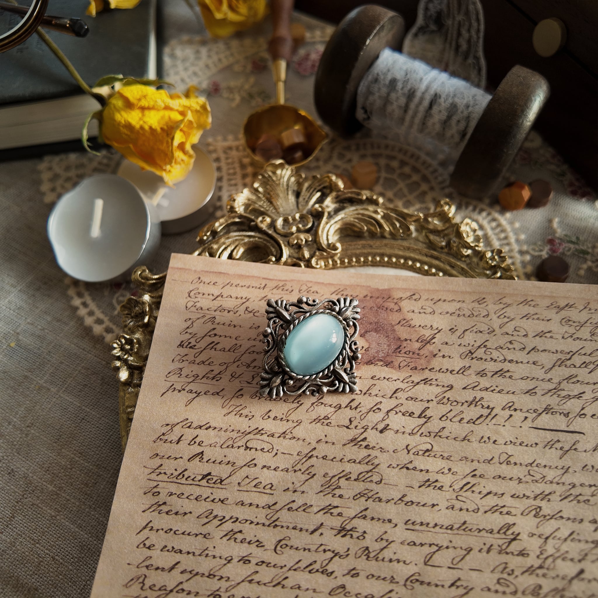 A frontal view of the faux moonstone brooch, showcasing the full view of this vintage brooch and revealing its size information based on the surrounding environment. This Victorian-style faux moonstone brooch displays different colors under different lighting conditions, sometimes resembling the blue of waves, and sometimes the white of moonlight.