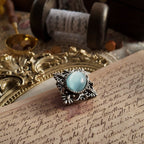 A close-up side view of the imitation opal brooch, showcasing the thickness of the opal protrusions and the details of the brooch's engraving.