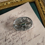 A close-up of the back of the silver cloisonné brooch, showcasing the condition of the back pin on this vintage Czech brooch.