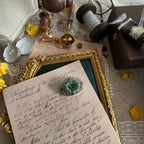 A silver cloisonné brooch set with emerald gemstones; a frontal view showing the full appearance of this vintage brooch from a distance.