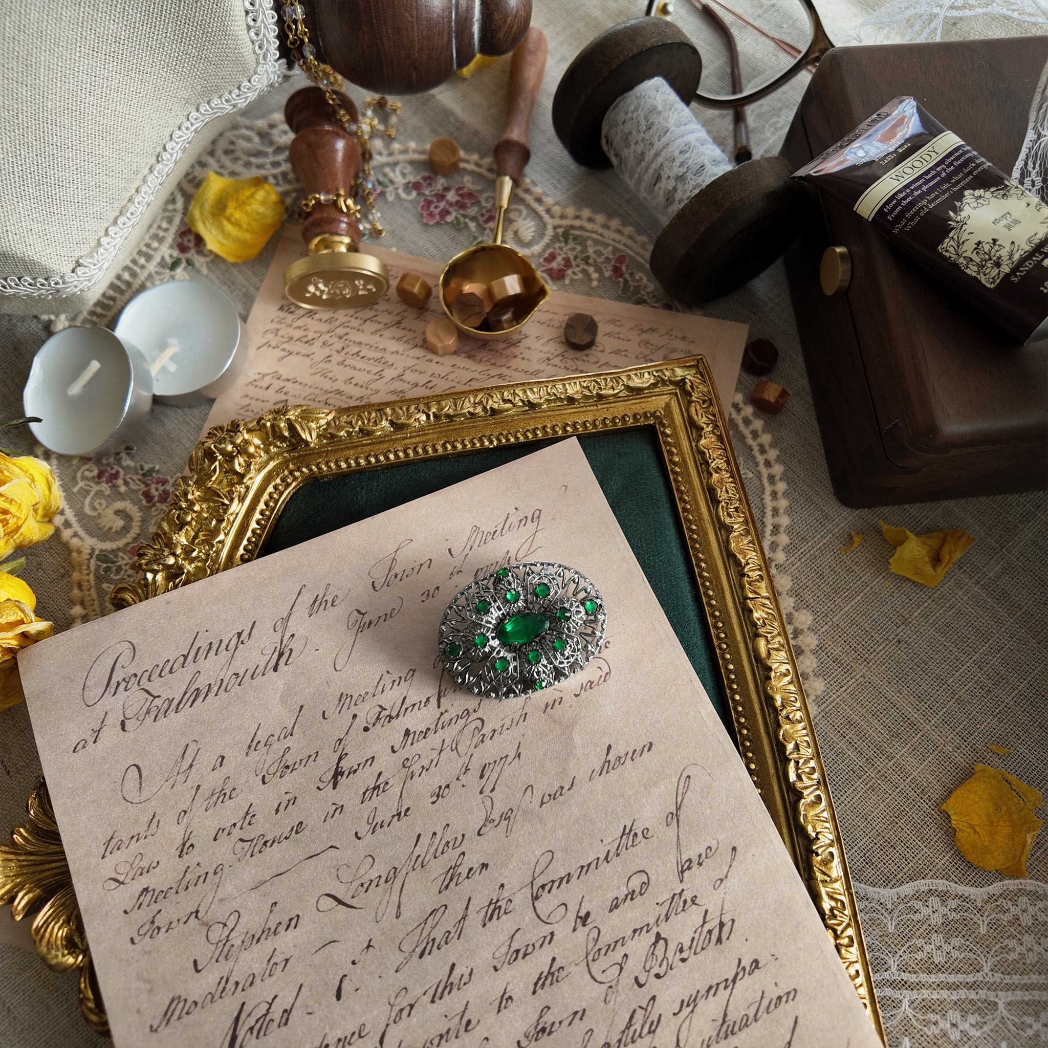 A silver cloisonné brooch set with emerald gemstones; a frontal view showing the full appearance of this vintage brooch from a distance.