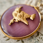 A bronze bird jewelry piece; the bird perches on a treetop, plump and adorable. Vintage animal jewelry, a sweet pendant necklace.