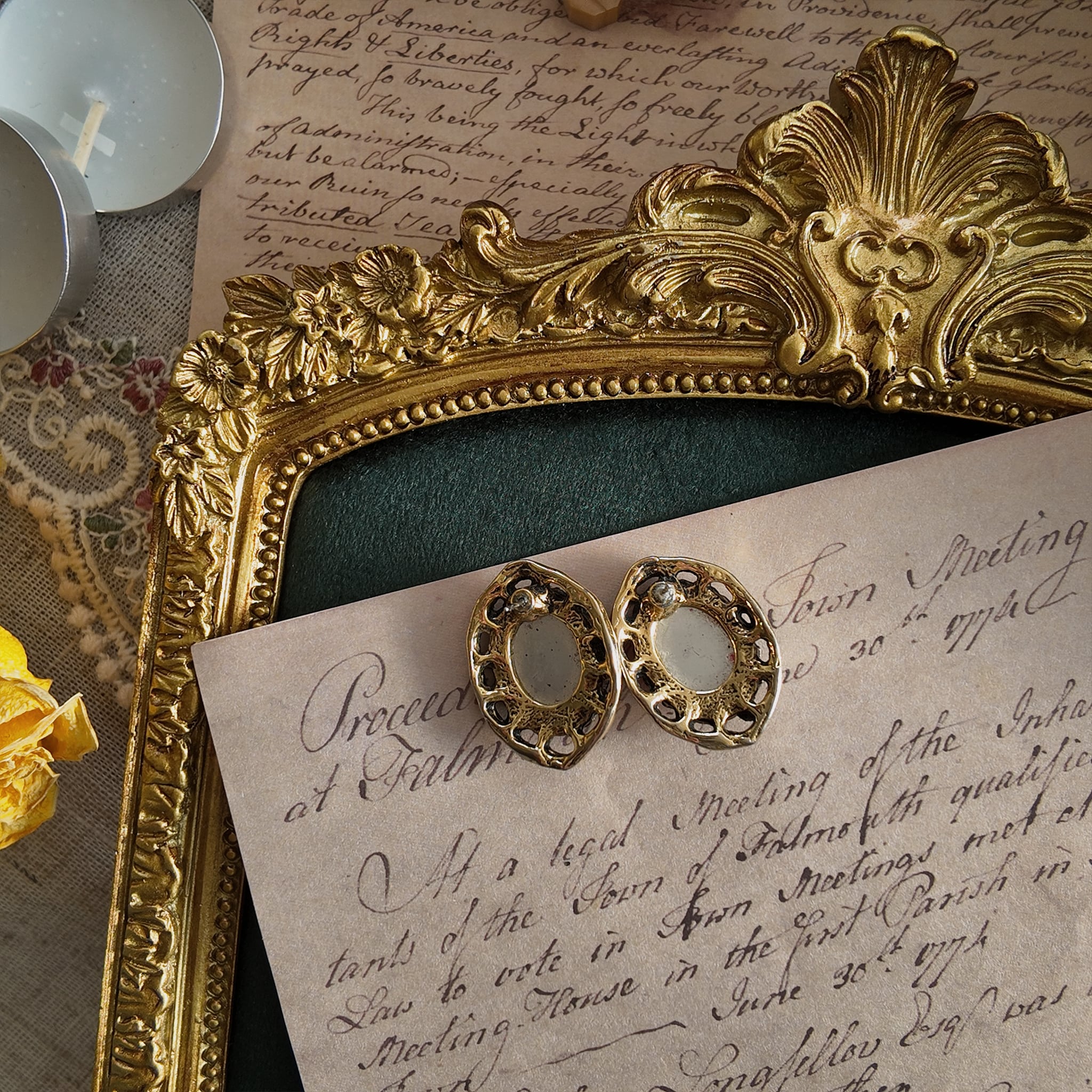 Showing the back of the vintage earrings, made of metal with a vintage patina and gold trim.