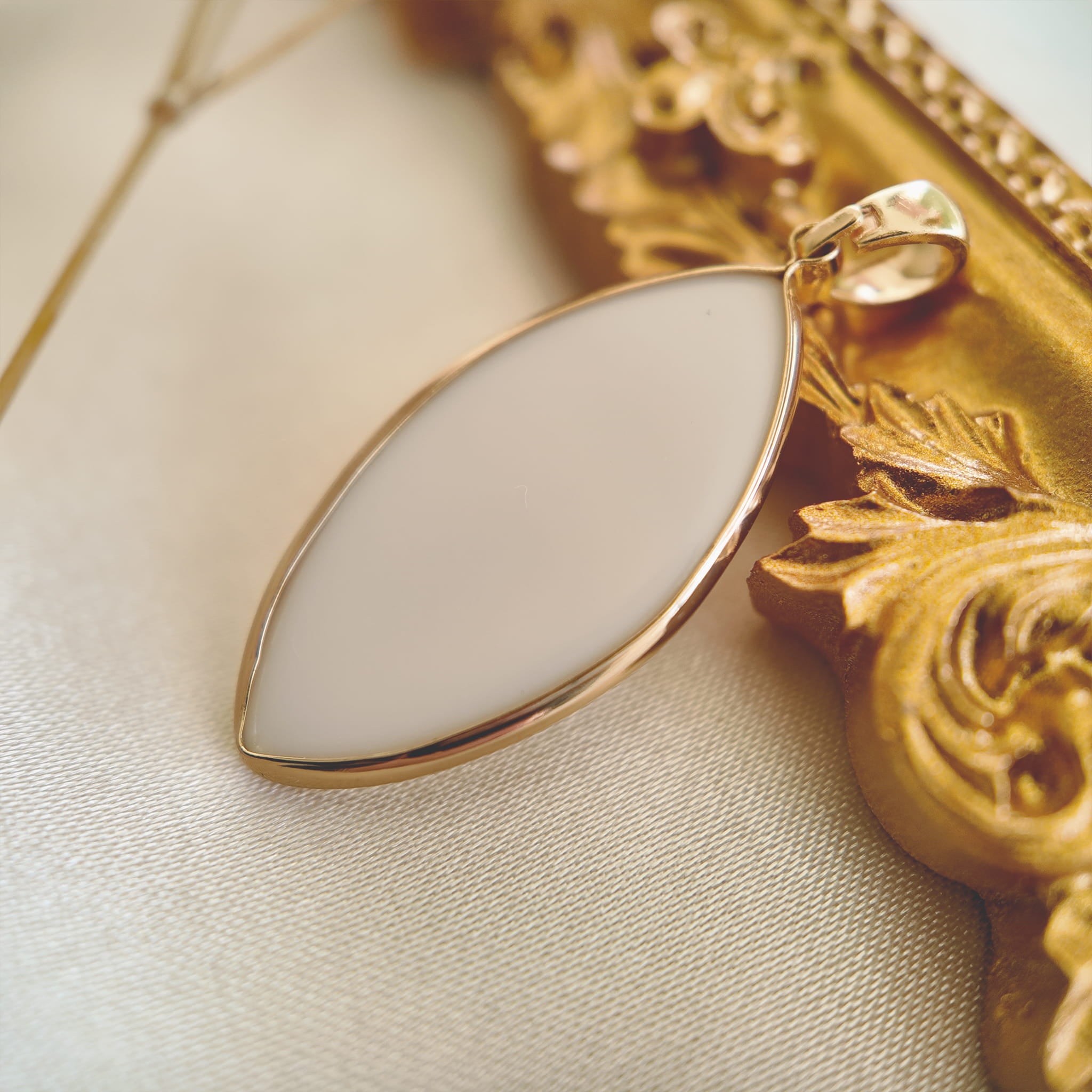  The Pearl Bow pendant next to a ruler, illustrating its 1.3 inches elegant marquise length.