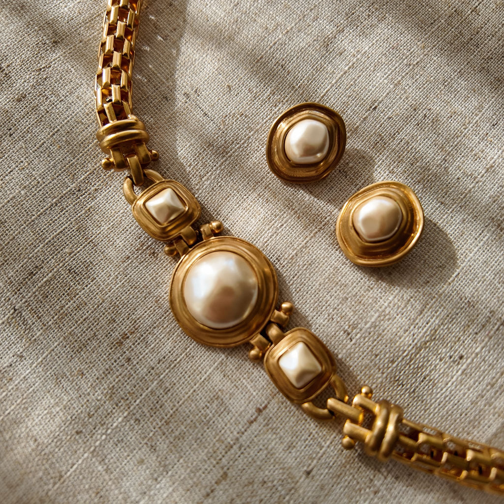 A macro shot detailing the unique, architectural plait design of the necklace chain and the organic, imperfectly perfect surface of a baroque pearl.