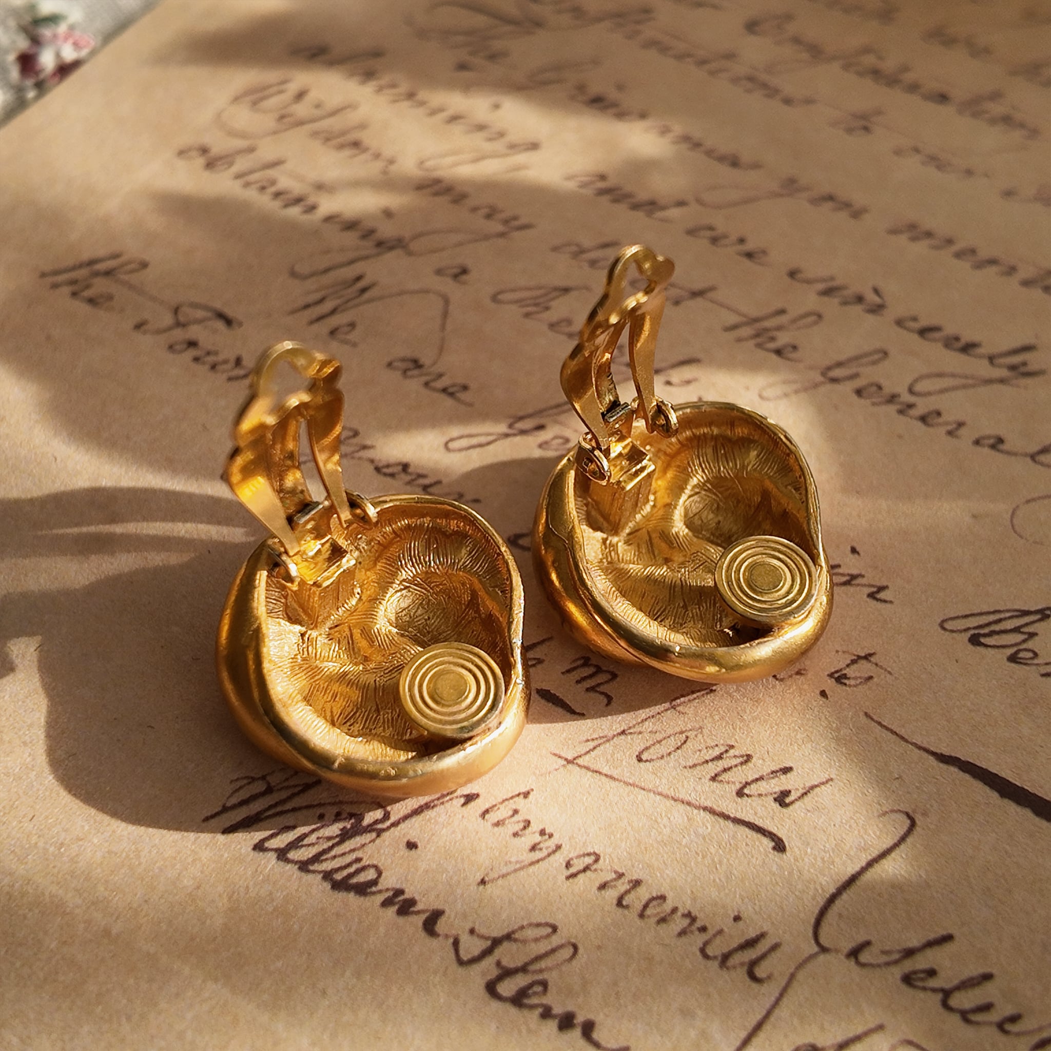 A detailed photo of the back of the Anne Klein earrings, clearly showing a localized area of gold loss, a testament to its "well-loved" history.