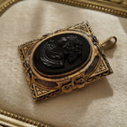 The Coro black glass cameo brooch worn on a lace collar, showcasing its sentimental charm and its identity as a piece of authentic, historical jewelry.