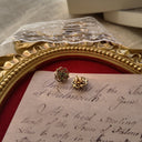 An angled view of the Rococo filigree earrings, highlighting the dimensional craftsmanship and the deep, authentic patina of the antiqued brass-tone metal.