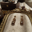 The "Art of Subtle Brilliance" Monet earrings styled on a wedding invitation to emphasize their identity as the perfect, timeless accessory for a bride or wedding guest.