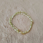 An angled view of the handmade necklace, highlighting the natural, pearlescent luster (orient) of the shell beads and the fluid drape of the choker.