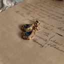 The "Reluctant Debutante" Avon earrings styled on a book of poetry to emphasize their intellectual, "quiet dignity" aesthetic, a treasure for the soulful collector.