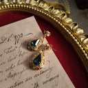 A detailed macro shot honestly showing the areas of plate loss and darkening on the gold finish, defining the "well-loved" character of these as-is vintage earrings.