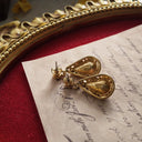 A close-up of the reverse side, showing the authentic "AVON" signature, as well as visible fading and oxidation on the gold-tone plating.
