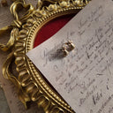 An angled view of the gold bell earrings, highlighting the bright, polished gold-tone finish and the classic, nostalgic Christmas motif.