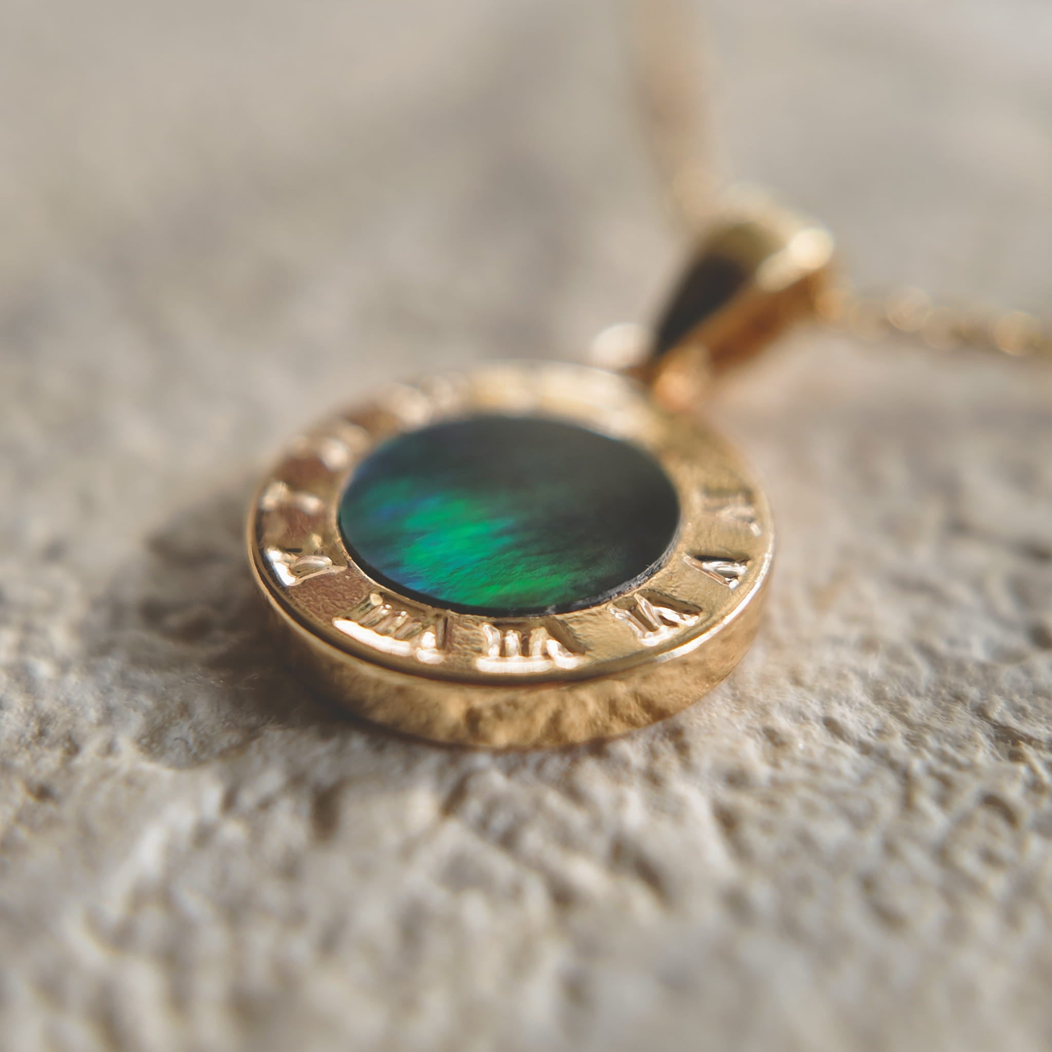 An angled view of the artisan charm, highlighting the intricate, 14k gold-plated filigree and the sparkling central cubic zirconia, with its gold-plated bail.