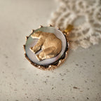 The "Bear Who Dreamed of Stars" celestial necklace from The Character Arc, featuring a vintage brass bear pendant on an iridescent Black Mother-of-Pearl base.
